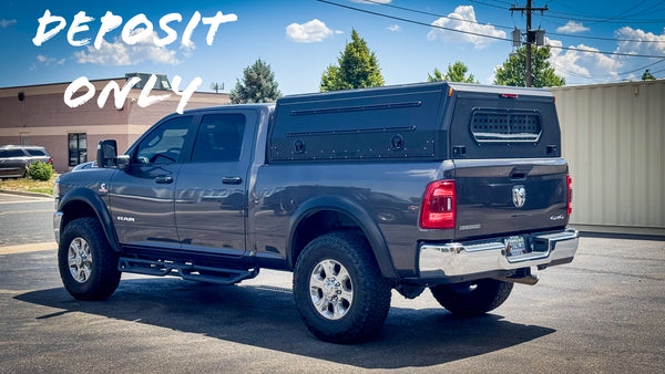Gray pickup truck with a truck topper in an outdoor setting