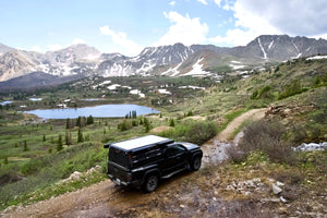 Toyota Tacoma overlanding in the mountains with a canopy camper from Dirtbox Overland