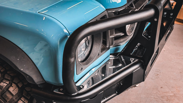 Side profile of the INEOS Grenadier modular bumper, showing the tight fitment against the body and the robust tubular bullbar design.